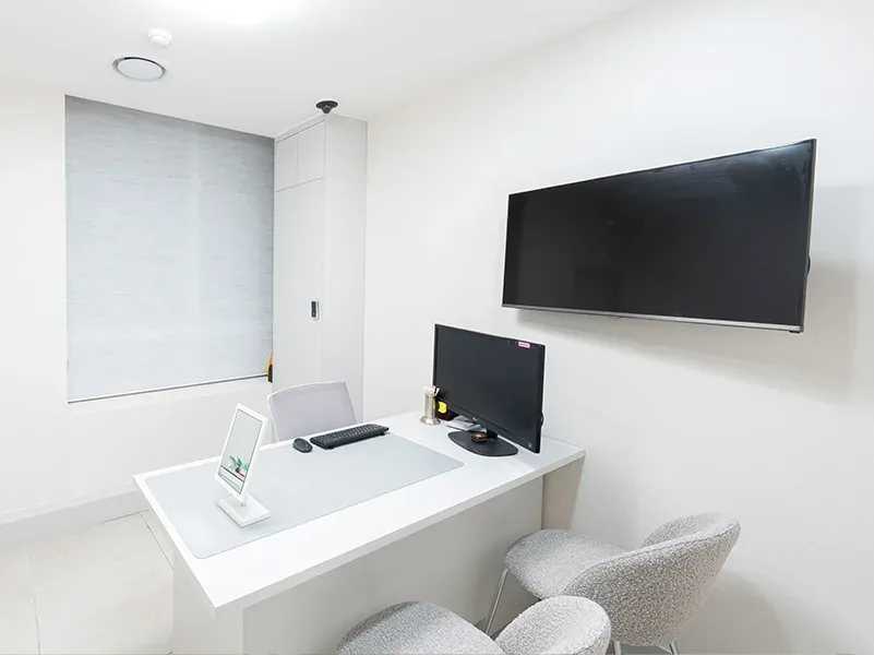 Consultation room with a desk, monitor and wall screen