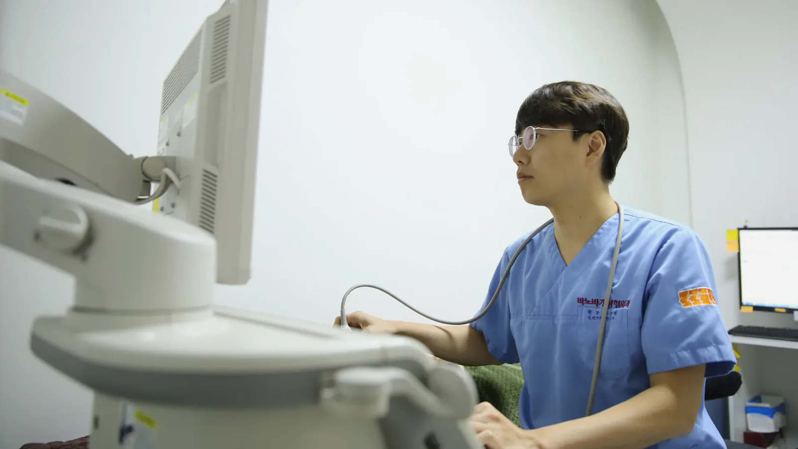 Staff member in scrubs operating an ultrasound system