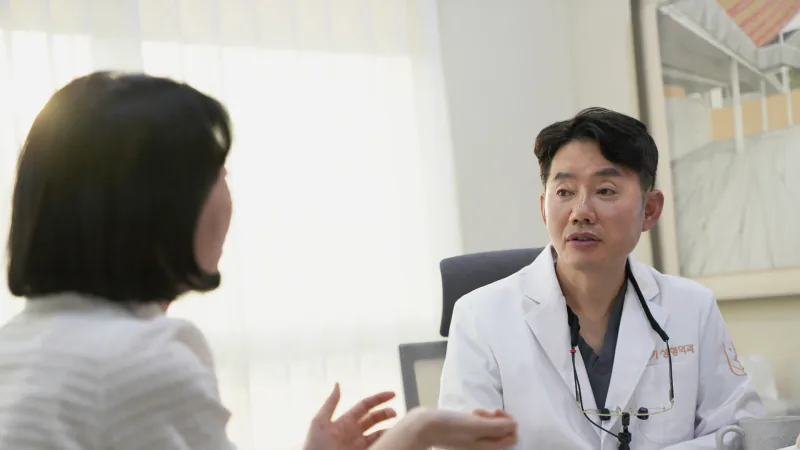 A surgeon talking with a patient in a consultation room